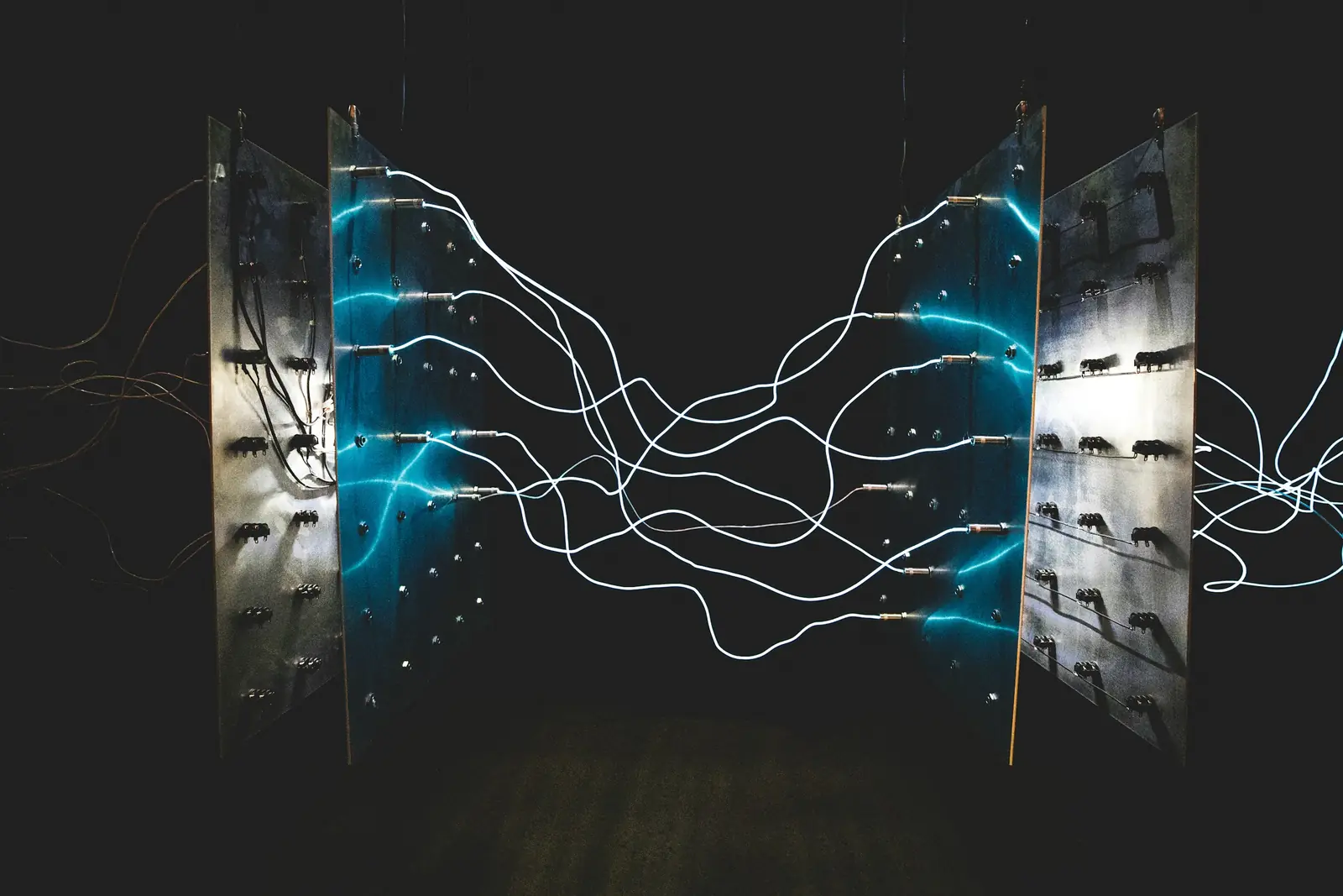 Glowing cables strung between two metal panels