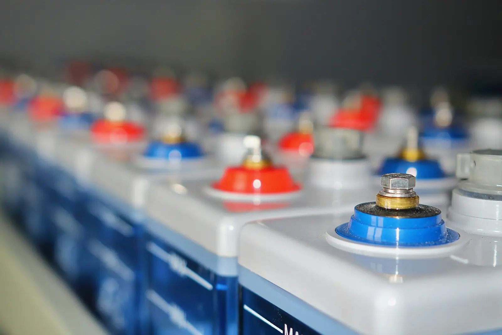 A row of battery cells with red and blue terminals