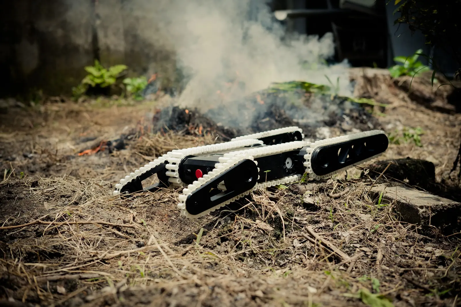 A tracked ground robot on rough, smoky ground